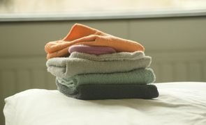 toalhas dobradas em cima de cama