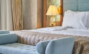 cama arrumada com sofa na frente